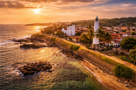 Galle Fort lighthouse at sunset on the southern coast of Sri Lanka with ocean and historic fort walls