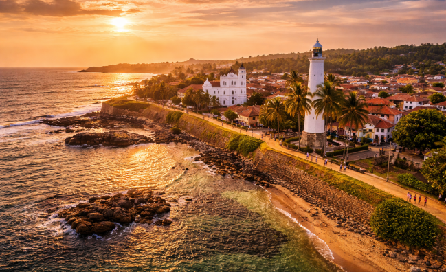 Galle Fort lighthouse at sunset on the southern coast of Sri Lanka with ocean and historic fort walls