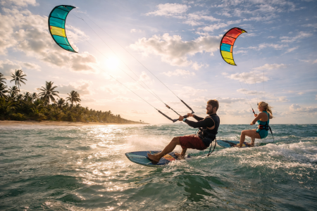 Kite surfers riding waves on Sri Lanka beach with colorful kites